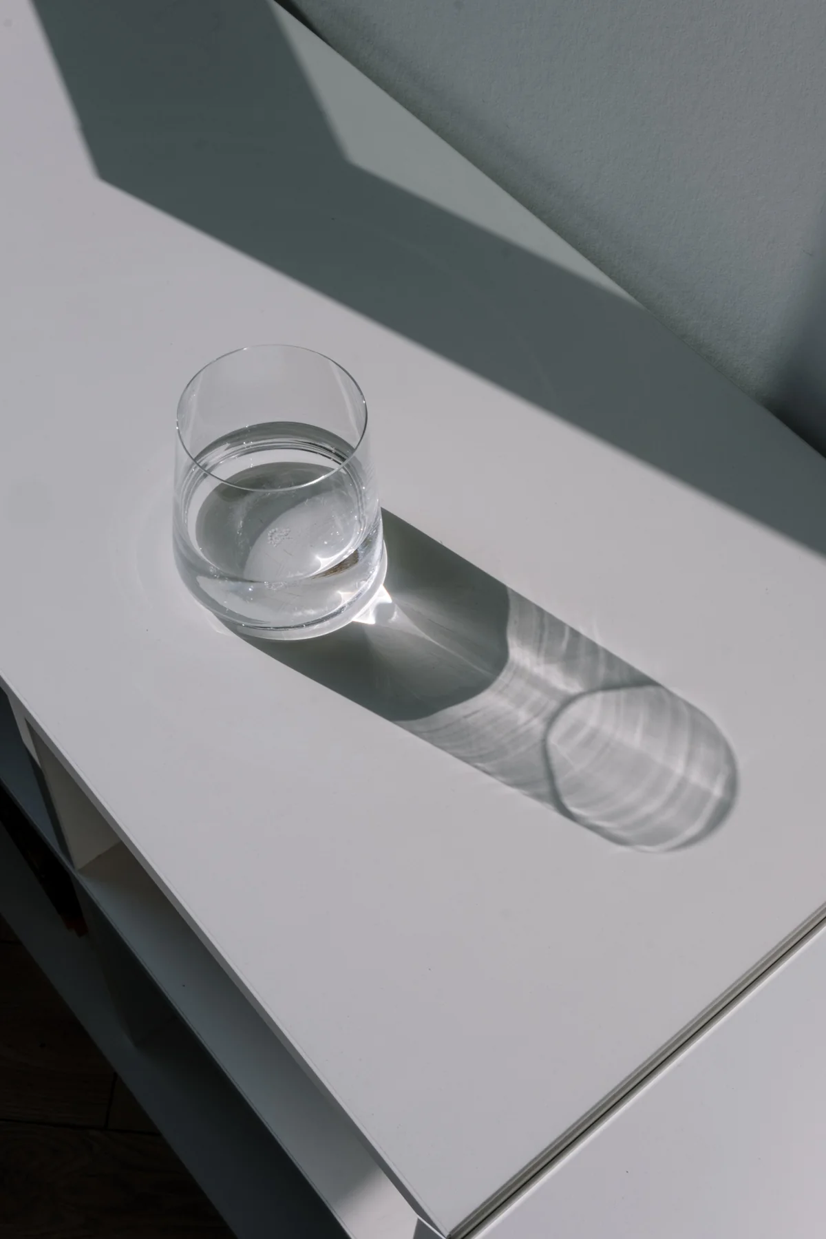 Verre d’eau transparent et son ombre dans une lumière naturelle