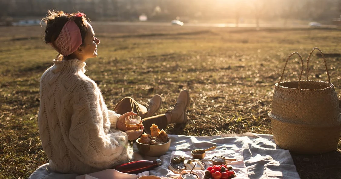 Une femme prépare un moment de repas en plein air