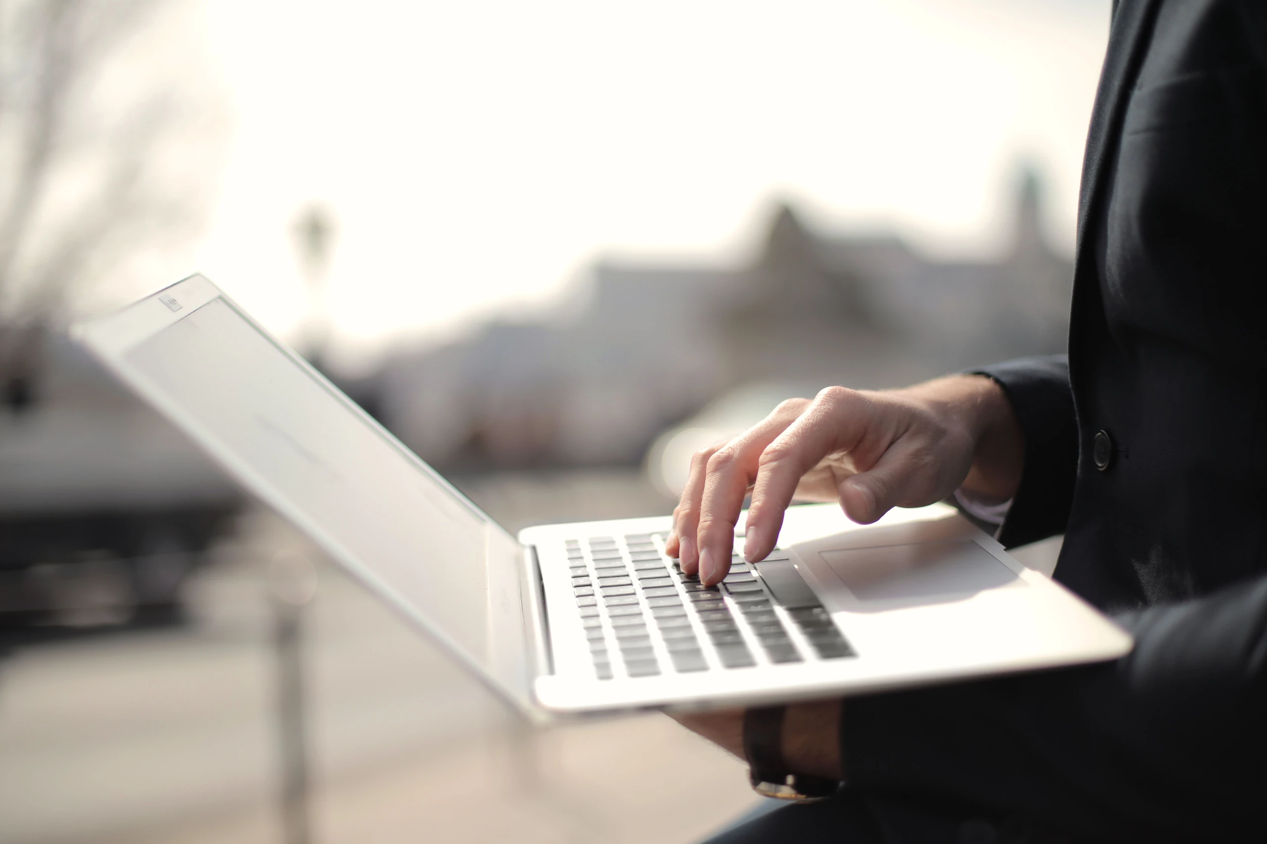 Mains utilisant un ordinateur portable à l’extérieur
